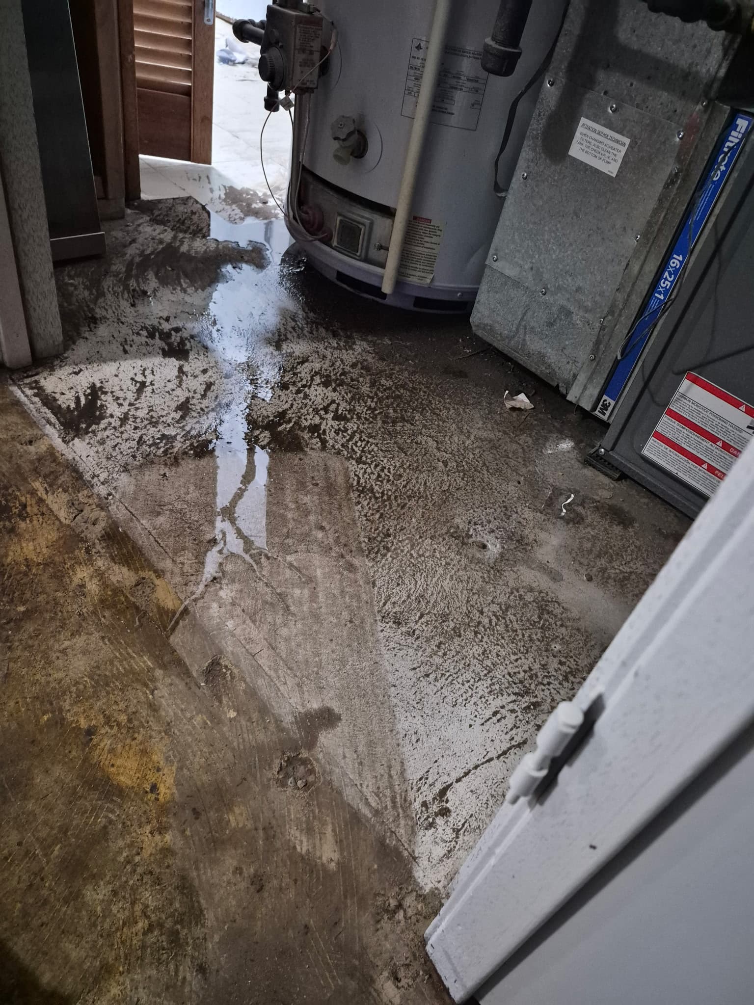 Standing water pooling around a utility room water heater
