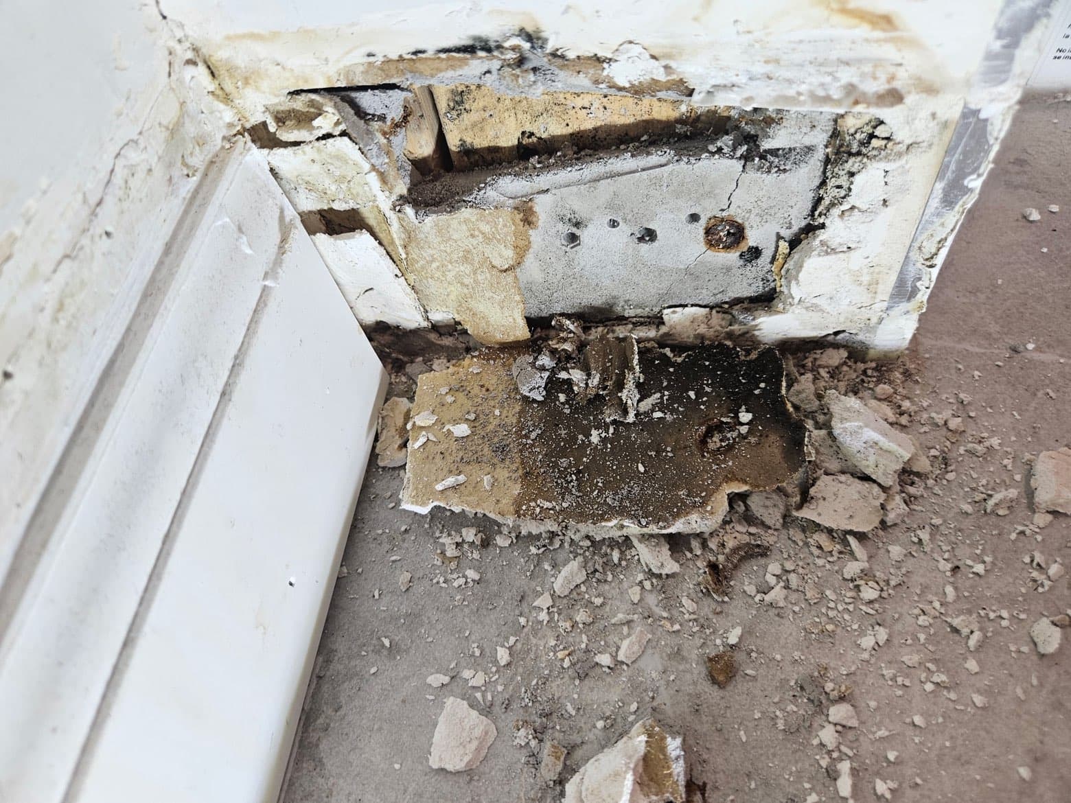 Mold and structural damage at baseboard before remediation